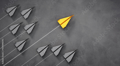 Group of paper airplanes with yellow leader plane on dark background