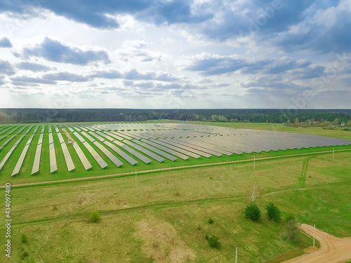Drone view of a solar power plant on a sunny day with clouds. Solar panels from a drone. Source of ecological renewable energy