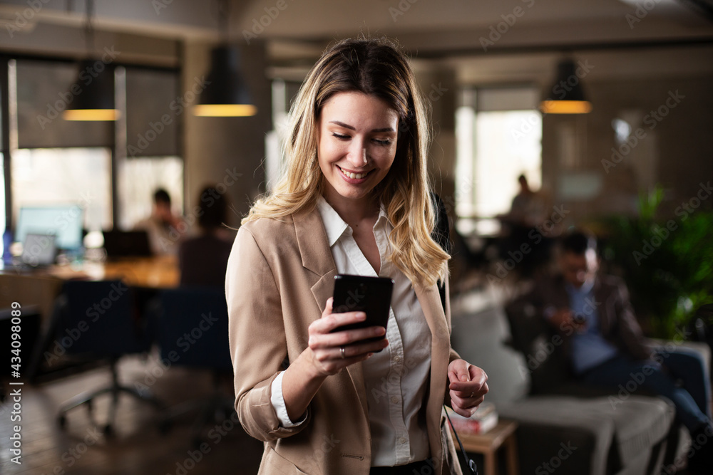 Businesswoman in office. Smiling beautiful businesswoman using the phone.