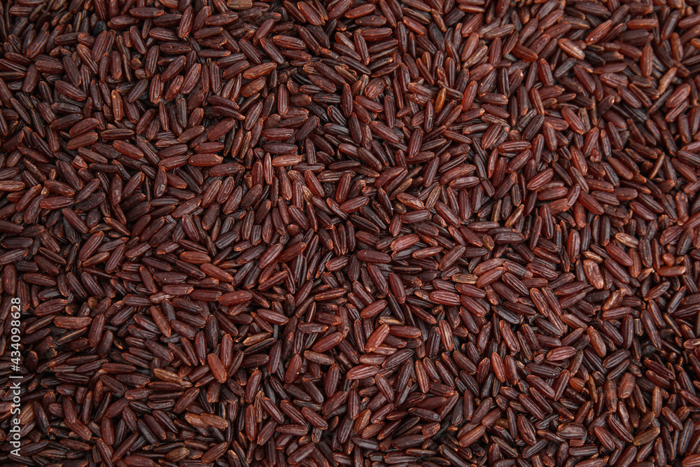 Heap of red rice as background, top view. Veggie seeds