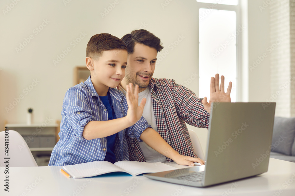 Video chat conference with teacher homeschooling concept. Father and boy child waving with hands greeting gesture looking at screen having online lesson with educator. Study from home Video chat conference with teacher homeschooling concept. Father and boy child waving with hands greeting gesture looking at screen having online lesson with educator. Study from home