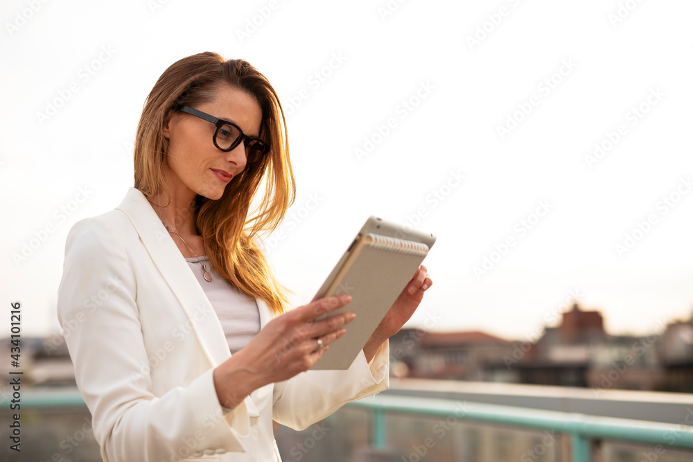 Urban businesswoman using tablet and working. Beautiful businesswoman outdoors Urban businesswoman using tablet and working. Beautiful businesswoman outdoors