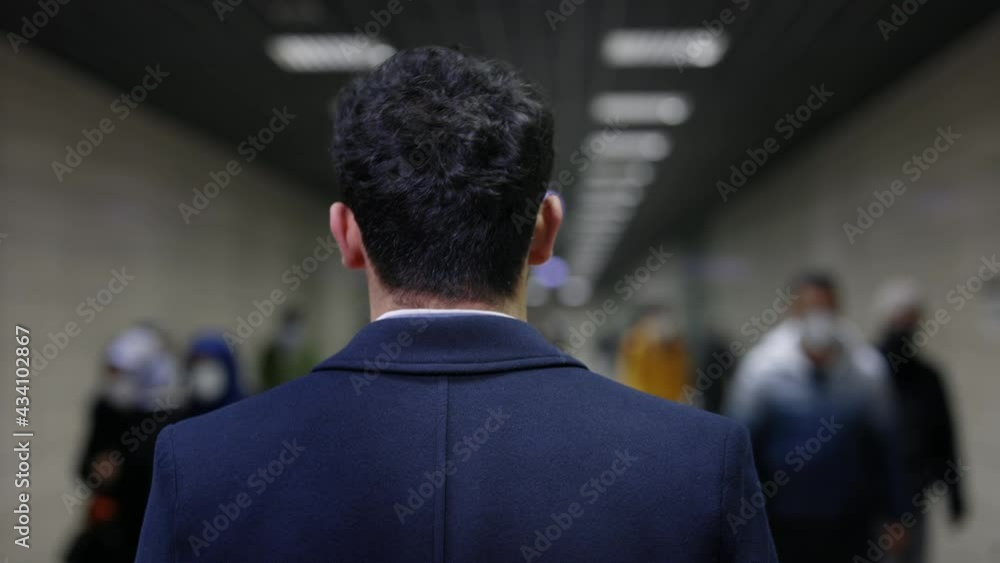Back view of businessman walking on metro station Back view of businessman walking on metro station