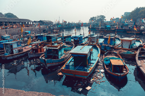 Mumbai, India, 30 november 2019 - A tour in the famous Sassoon Docks fish market. View of the fishermen's boats docked in the port in the dirty water. Environmental pollution. photo