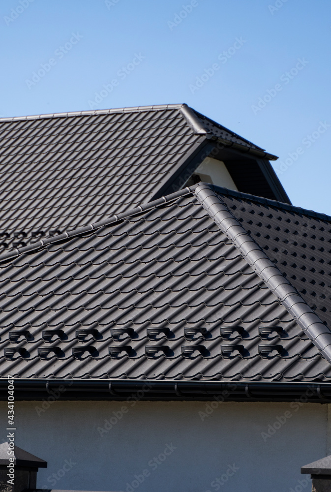 Brown corrugated metal profile roof installed on a modern house. The roof of corrugated sheet. Roofing of metal profile wavy shape. Modern roof made of metal. Metal roofing. Brown corrugated metal profile roof installed on a modern house. The roof of corrugated sheet. Roofing of metal profile wavy shape. Modern roof made of metal. Metal roofing.