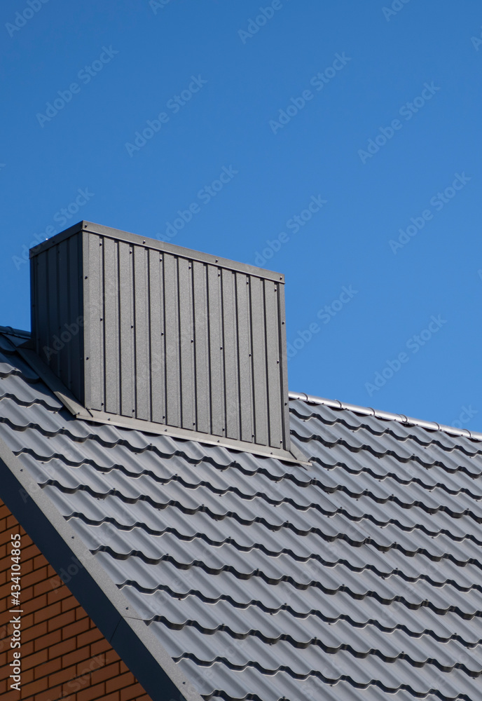 Grey corrugated metal profile roof installed on a modern house. The roof of corrugated sheet. Roofing of metal profile wavy shape. Modern roof made of metal. Metal roofing.