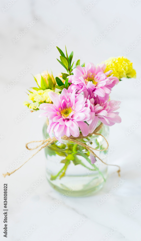 A bouquet of delicate flowers in a transparent jar