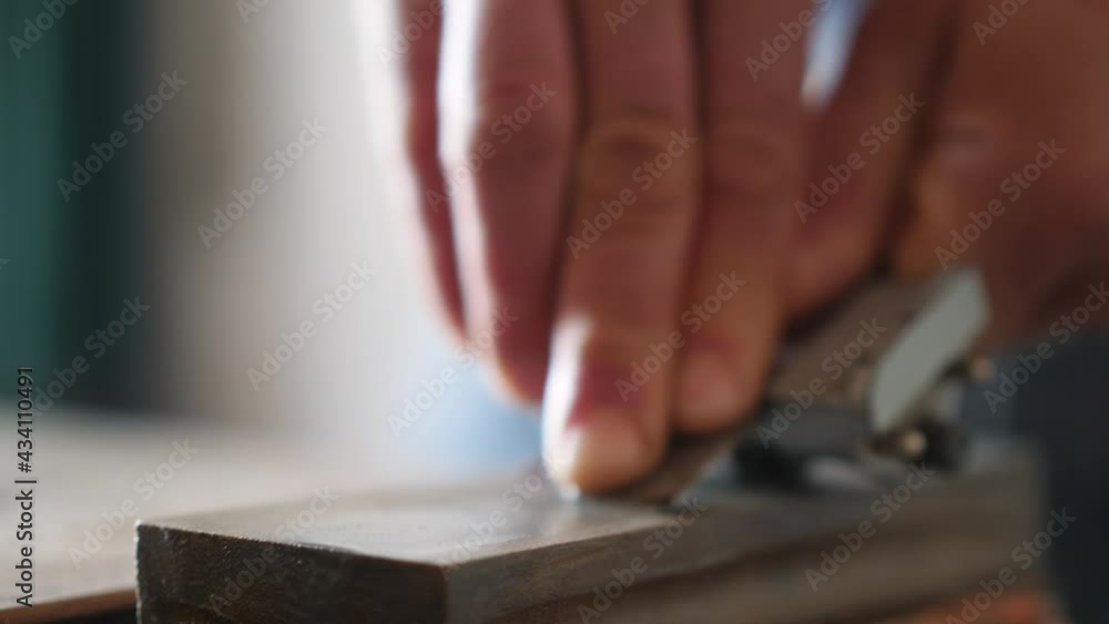 sharpening a chisel on a grinder. professional tool sharpening. carpenter sharpens a chisel before carving wood sharpening a chisel on a grinder. professional tool sharpening. carpenter sharpens a chisel before carving wood