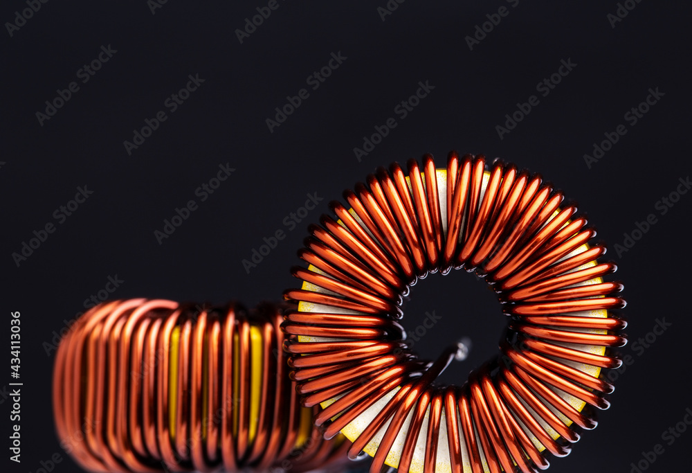 Close-up of copper wire coil on black background. - obrazy, fototapety, plakaty 