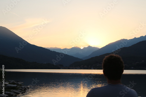a man watching the sunset on the lake
