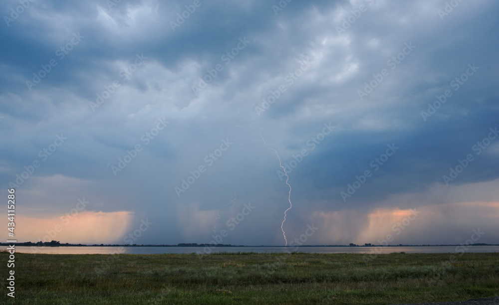 Lightning strike and stormy cloud over field