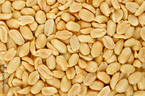 Roasted and salted peanuts, background, from above. Snack food, made from fruits of Arachis hypogaea, also groundnut, goober, pindar or monkey nut, with high oil content. Backdrop. Macro food photo. photo