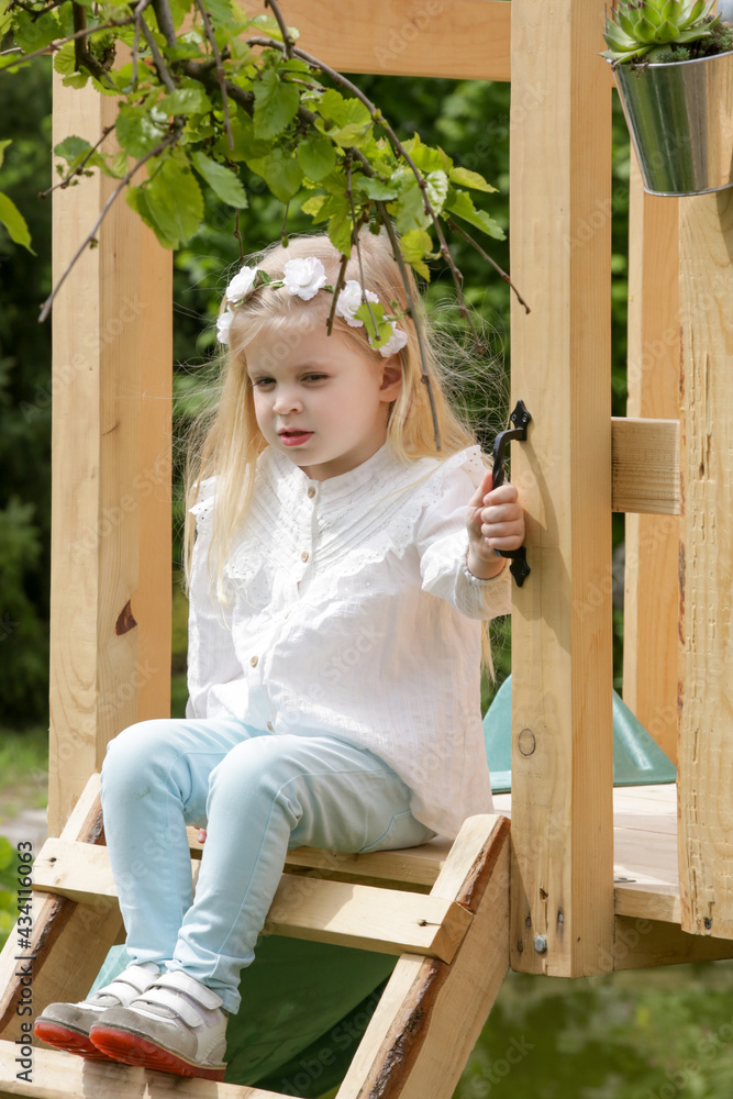 Cute toddler girl playing in the wooden tree house Cute toddler girl playing in the wooden tree house
