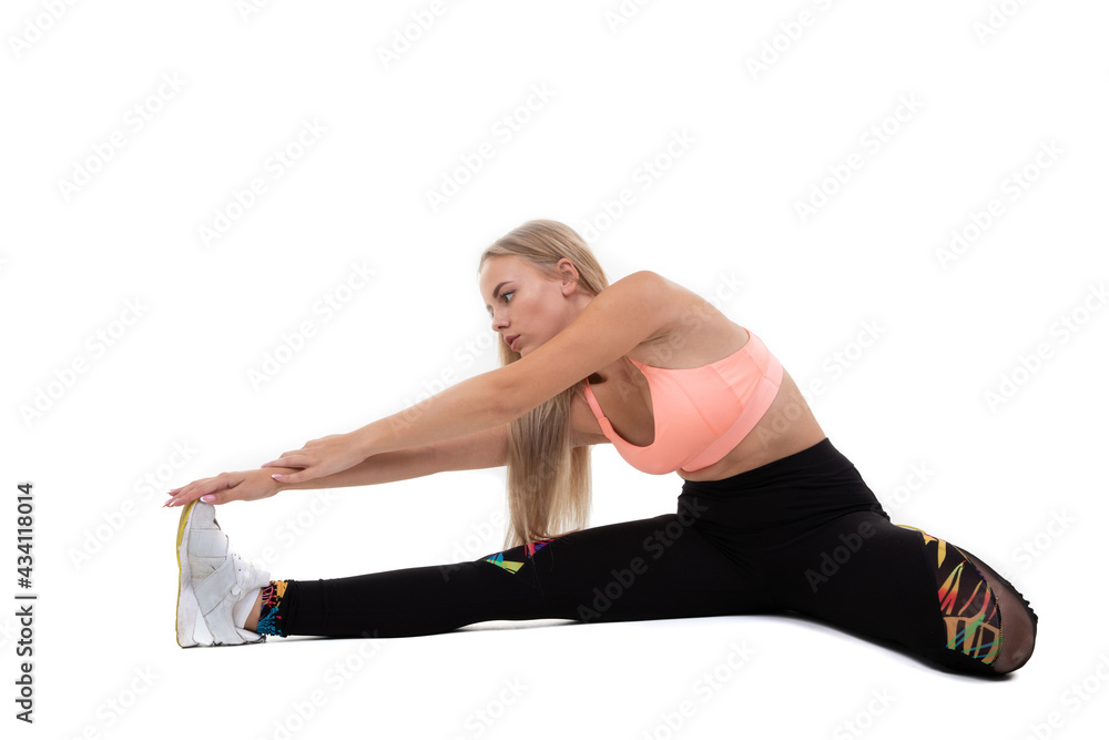 A sporty young woman in a pink top, leggings and sneakers does exercises on a white background A sporty young woman in a pink top, leggings and sneakers does exercises on a white background