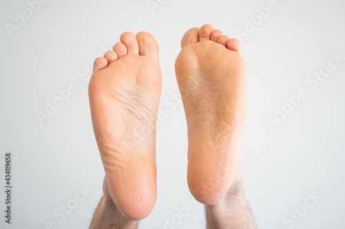 Caucasian male bare sole feet top view close up shot isolated on white