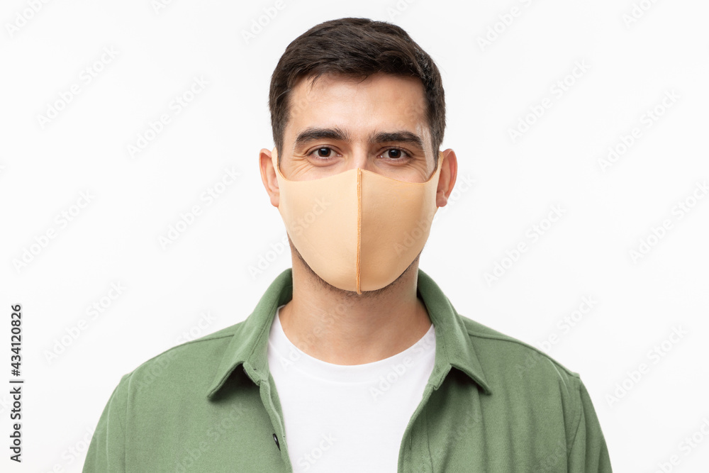 Young man wearing trendy green cargo shirt and beige mask standing isolated on gray background Young man wearing trendy green cargo shirt and beige mask standing isolated on gray background