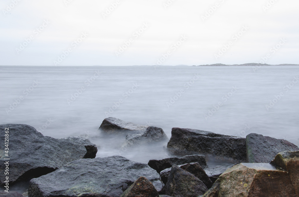 Long exposure photo of beautiful cold ocean waves and rocks. Seasonal. Swedish West coast.