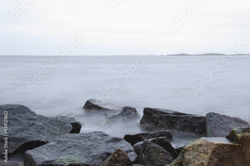 Long exposure photo of beautiful cold ocean waves and rocks. Seasonal. Swedish West coast.