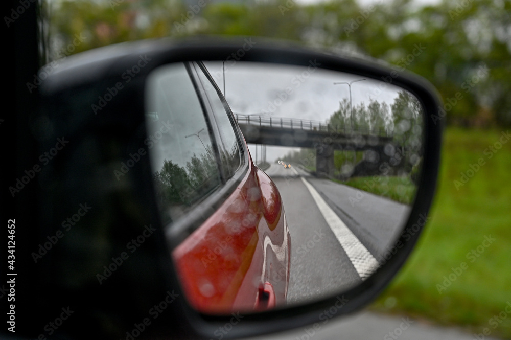 looking through side mirror at bridge over highway