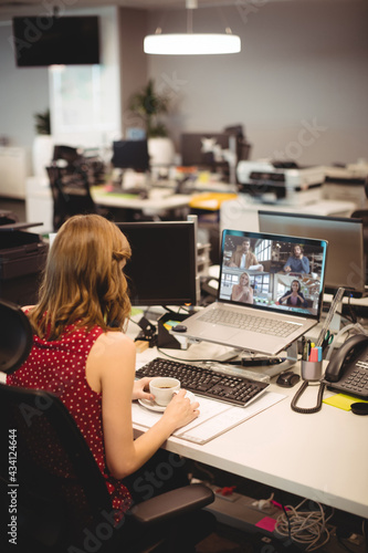 Caucasian businesswoman sitting at desk using laptop having video call with colleagues