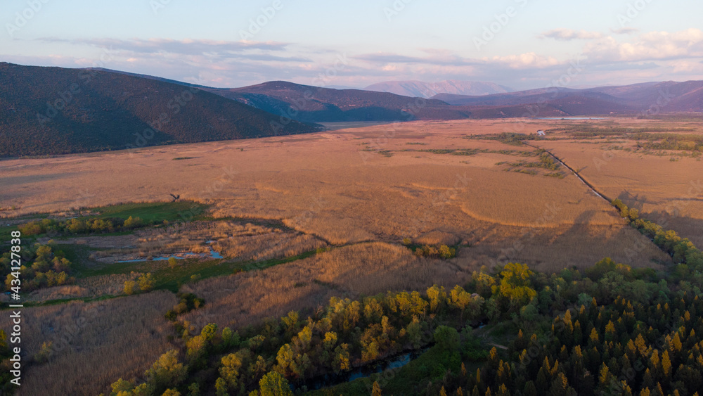Aerial drone view of lake covered with reeds. Landscape. Colorful swampy marsh in spring. Hutovo blato, nature reserve and bird reserve located in Bosnia and Herzegovina. 