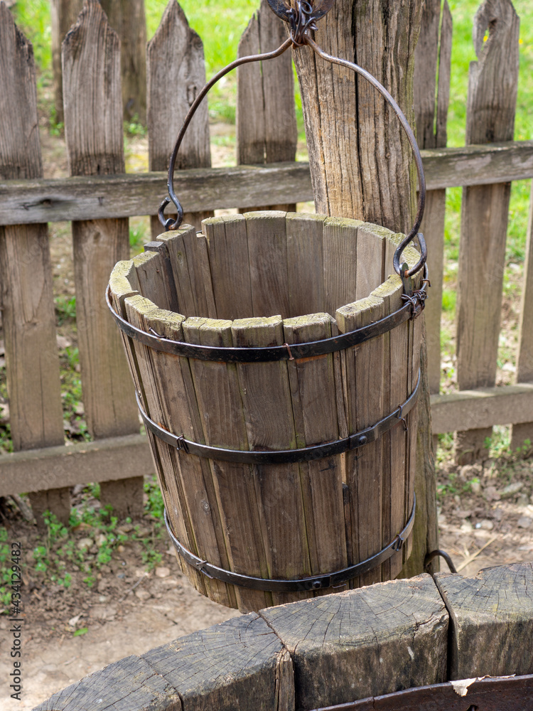 Vertical shot of a wooden basket on a well