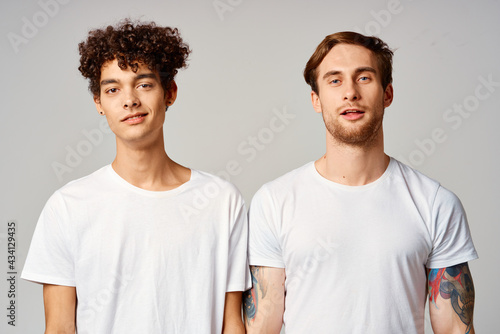 two friends in white t-shirts fun emotions isolated background