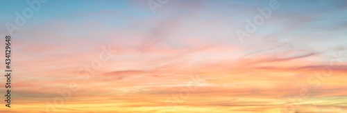 Clear blue sky. glowing pink and golden cirrus and cumulus clouds after storm, soft sunlight. Dramatic sunset cloudscape. Meteorology, heaven, peace, graphic resources, picturesque panoramic scenery