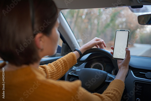 Mockup image of a woman holding and using mobile phone