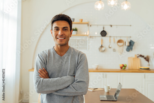Portrait of smart smiling Caucasian man standing with arms folded at home posing for photos with copy space. Attractive middle age female freelancer looking at camera