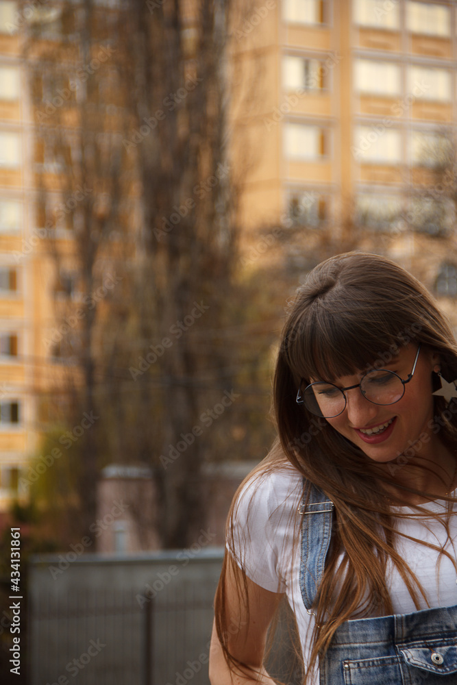 Smiling girl in glasses in the city