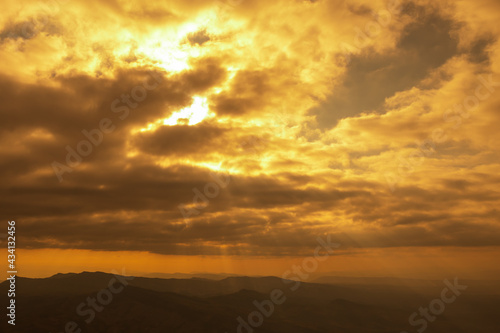 Landscape photo of sunset over clouds with mountain hill forest. in golden light tone.