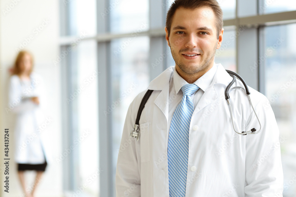 Male dark hair doctor standing in the modern clinic. Perfect medical service in the hospital. Medicine concept