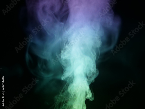 Abstract color series. Composition of colorful smoke in motion. Fusion of purple and green mist isolated on a dark background to inspire creativity.