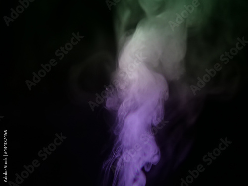 Abstract color series. Composition of colorful smoke in motion. Fusion of purple and green mist isolated on a dark background to inspire creativity.