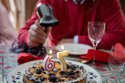 Covid manque de souffle, un homme âgé souffle ses bougies d'anniversaire avec un sèche cheveux