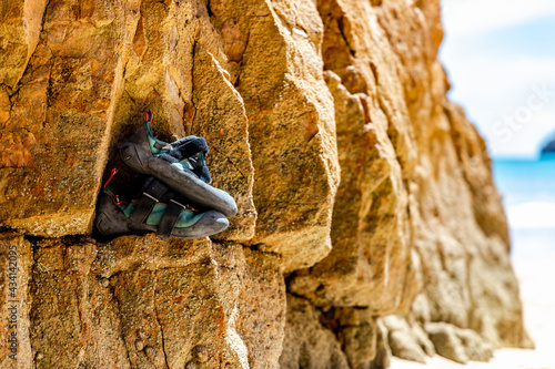 Professional climber shoes on the rock by the beach