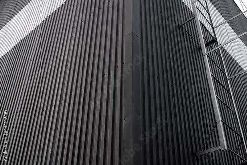 Black and white corrugated iron sheet used as a facade of a warehouse or factory. Texture of a seamless corrugated zinc sheet metal aluminum facade. Architecture. Metal texture.