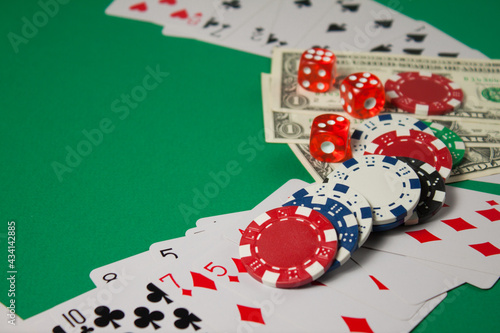 Classic playing cards, chips, red dice and dollars on green background. Gambling and casino concept.