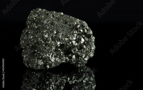 A cluster of pyrite crystals. Isolated on a black mirror background. photo