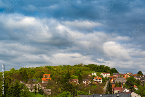 Wallpaper Mural Heavy, rainy clouds over the green hill with houses. Beautiful countryside scenery. Torontodigital.ca