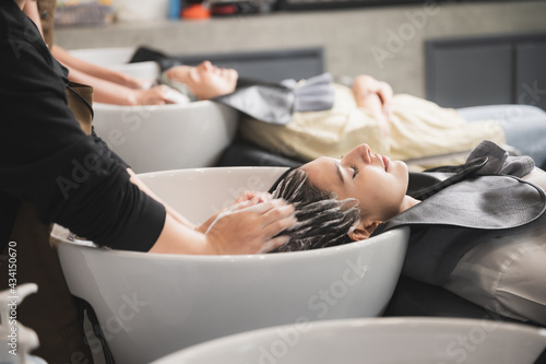 Fotobehang professional hairdresser working to water washing hair clean with woman client i