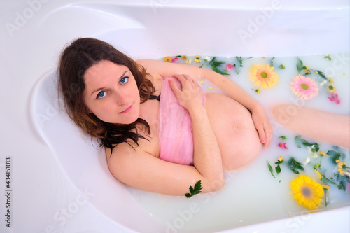 Red and yellow flowers in water with a pregnant woman