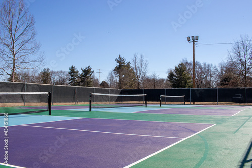 Blue, green, and purple tennis court or pickle ball court under blue sky in winter