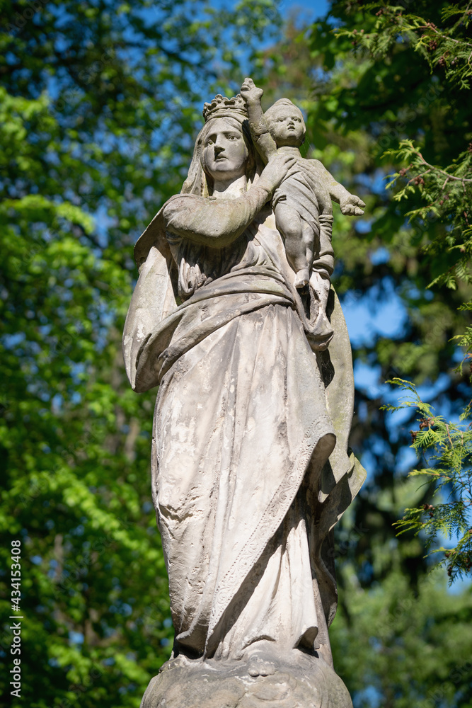 Queen of Heaven. Ancient statue of the Virgin Mary with Jesus Christ. Fragment of an ancient statue. Vertical image.