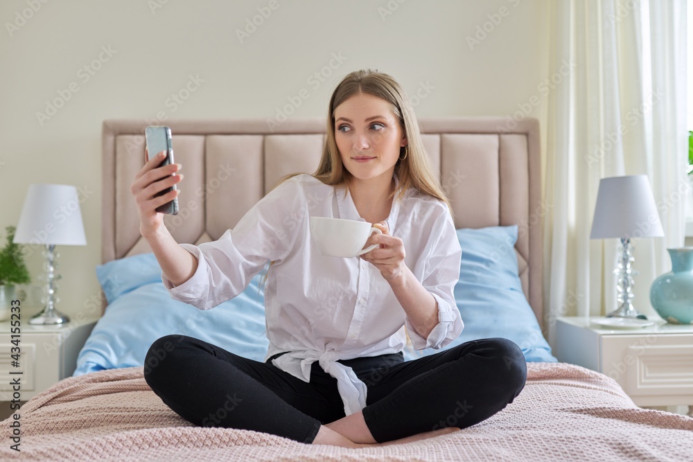 Happy talking young woman using video communication on smartphone Happy talking young woman using video communication on smartphone