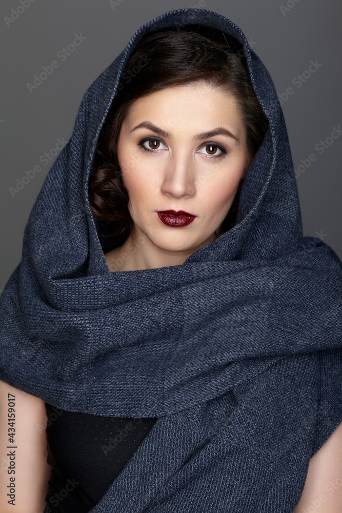 Beauty portrait of brunette woman dressed in dark blue scarf. Beauty portrait of brunette woman dressed in dark blue scarf.