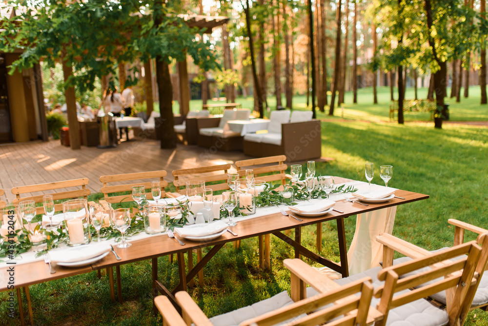 setting a wedding banquet in the forest. Rustic style. Green branch and candles. Celebrating a wedding