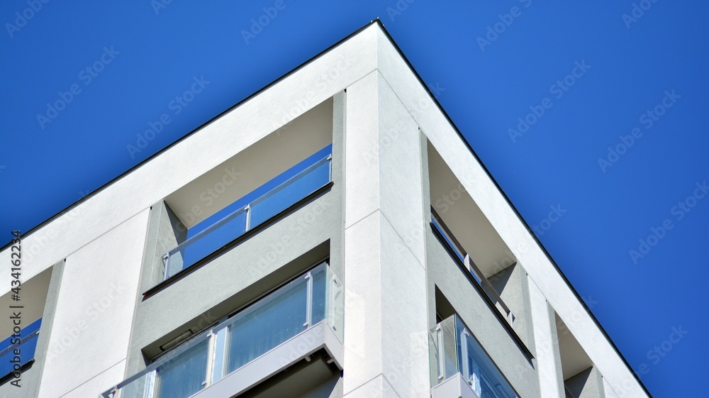 Condominium and apartment building with symmetrical modern architecture. Detail in modern residential flat apartment building exterior. Fragment of new luxury house and home complex. Condominium and apartment building with symmetrical modern architecture. Detail in modern residential flat apartment building exterior. Fragment of new luxury house and home complex.
