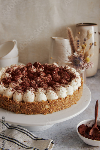 Vertical shot of a delicious Bonafi Cream Pie with chocolate powder on a beautifully decorated table photo